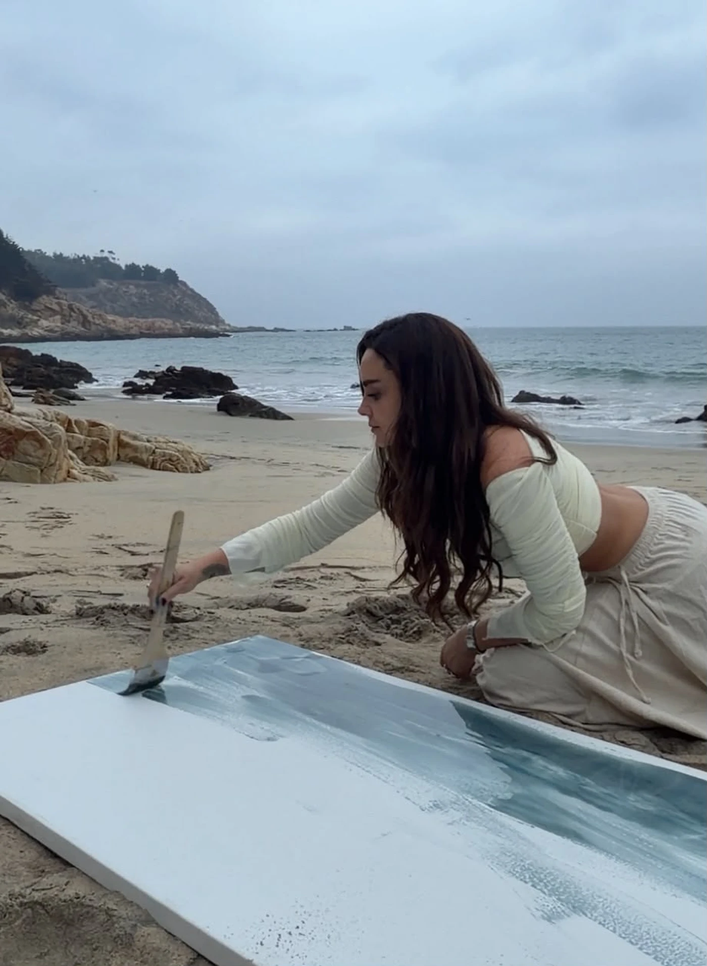 Camila Miguel pintando en la playa